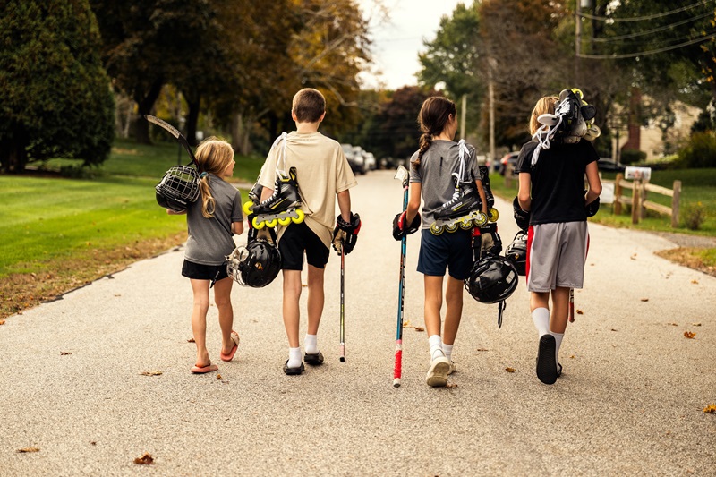 Děti s hokejkami a in-line bruslemi